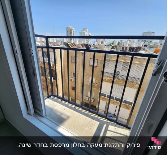 מרפסת עם מעקה מתכת שחור וחלון פתוח